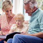 Grandparents and granddaughter looking through a family photo album, representing adoption record access in Ireland